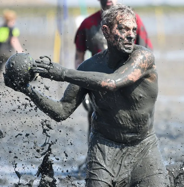 A player throws a ball during a handball match at the so called “Wattoluempiade” (Mud Olympics) in Brunsbuettel at the North Sea, July 11, 2015. (Photo by Fabian Bimmer/Reuters)