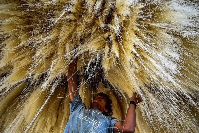A worker stacks vermicelli which is used in making traditional sweet dishes popularly consumed during the holy month of Ramadan, at a factory in Allahabad on April 5, 2022. (Photo by Sanjay Kanojia/AFP Photo)