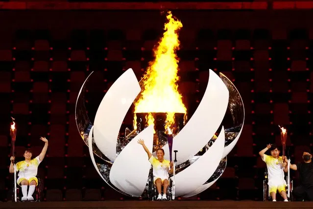 Yui Kamiji (C), Shunsuke Uchida (R), Karin Morisaki (L) of Team Japan light the Paralympic flame during the opening ceremony of the Tokyo 2020 Paralympic Games at the Olympic Stadium on August 24, 2021 in Tokyo, Japan. (Photo by Athit Perawongmetha/Reuters)