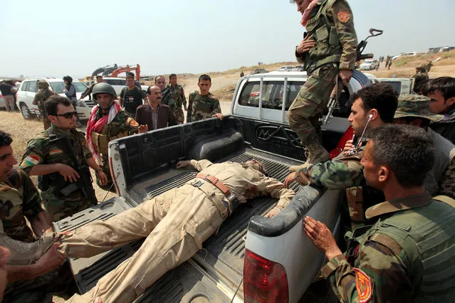 Kurdish Peshmerga forces carry their comrade, who was given an injection after he was wounded, in the back of the car in a village east of Mosul, Iraq, May 29, 2016. (Photo by Azad Lashkari/Reuters)