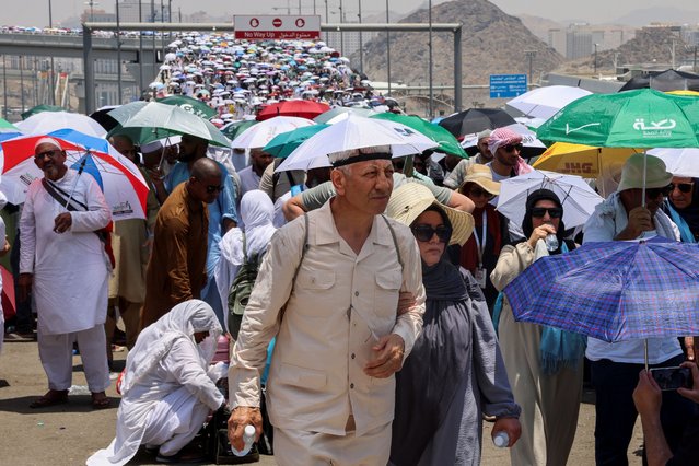 Muslim pilgrims walk with umbrellas on the third day of the Satan stoning ritual, amid extremely hot weather, during the annual haj pilgrimage, in Mina, Saudi Arabia, on June 18, 2024. (Photo by Saleh Salem/Reuters)