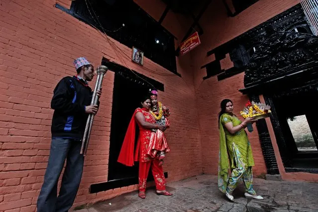 A file picture dated 19 April 2011 shows Purna Shova Bajracharya (2-L), mother of Kumari Samita Bajracharya (2-R), as she carries her daughter to a festival procession in Patan, Nepal. Kumari, the living goddess, appears outside of her residence during different jatras for nine times a year as a guest. Kumari, or Kumari Devi, is a “living goddess”. The word literally means virgin in Nepali. The Living Goddesses are young pre-pubescent girls that are considered to be incarnations of the Hindu Goddess of Power, Kali. The Kumari retires when she reaches puberty. (Photo by Narendra Shrestha/EPA)