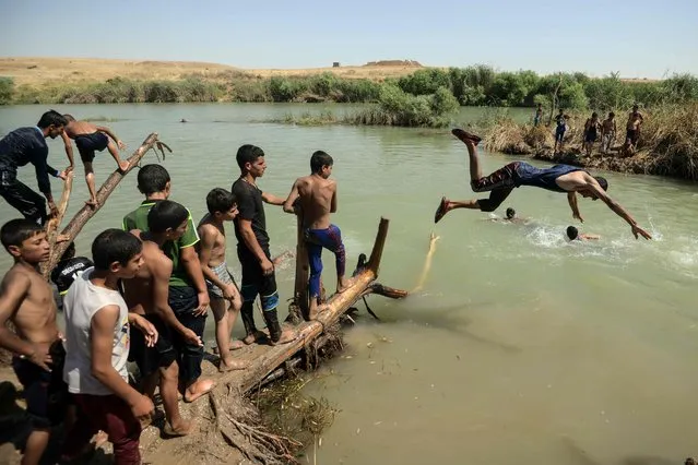 Iraqis staying at the al-Khazir camp swim in a river near the camp for internally displaced people, located between Arbil and Mosul on June 11, 2017. (Photo by Mohamed El-Shahed/AFP Photo)