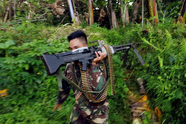 A Philippines army soldier runs with a machine gun in Marawi city, Philippines June 28, 2017. (Photo by Jorge Silva/Reuters)