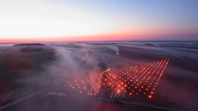 An aerial view taken near Vernou-sur-Brenne, central France, on April 4, 2022 shows the fires set in the Vouvray vineyards to protect them from the frost. (Photo by Guillaume Souvant/AFP Photo)