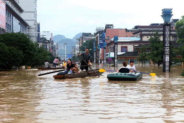 People make their way with boats through a flooded area in Liuzhou, Guangxi province, China on July 3, 2017. (Photo by Reuters/Stringer)
