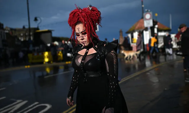 A participant walks through town during the biannual “Whitby Goth Weekend” festival in Whitby, northern England, on October 31, 2021. (Photo by Oli Scarff/AFP Photo)
