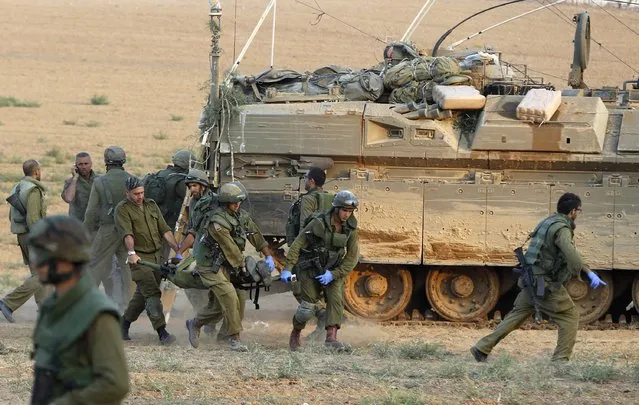 Israeli soldiers carry a comrade on a stretcher, who was wounded during an offensive in Gaza, outside northern Gaza July 20, 2014. Israel said on Sunday it had expanded its ground offensive in Gaza and militants kept up rocket fire into the Jewish state with no sign of a diplomatic breakthrough to end the worst fighting between Israel and Hamas in two years. (Photo by Baz Ratner/Reuters)