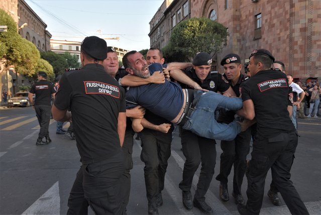 Armenian police officers detain a protester outside the government building in central Yerevan on August 8, 2023. Armenian police on August 8, 2023 detained a dozen protesters, mostly war veterans, in central Yerevan after they blocked a government building, demanding authorities take steps to unblock the Lachin corridor, shut down by neighbour and foe Azerbaijan. The Lachin corridor is the sole road linking the breakaway Armenian-populated region of Nagorno-Karabakh – over which Yerevan and Baku fought two wars – with Armenia. (Photo by Karen Minasyan/AFP Photo)