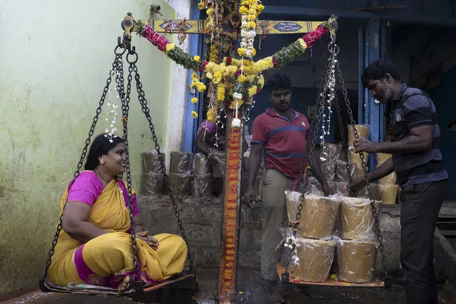 A Hindu devotee sits on a scale to buy his weight in jaggery as an offering to goddesses during Sammakka Saralamma Jatara festival, in Hyderabad on February 5, 2020. (Photo by Noah Seelam/AFP Photo)