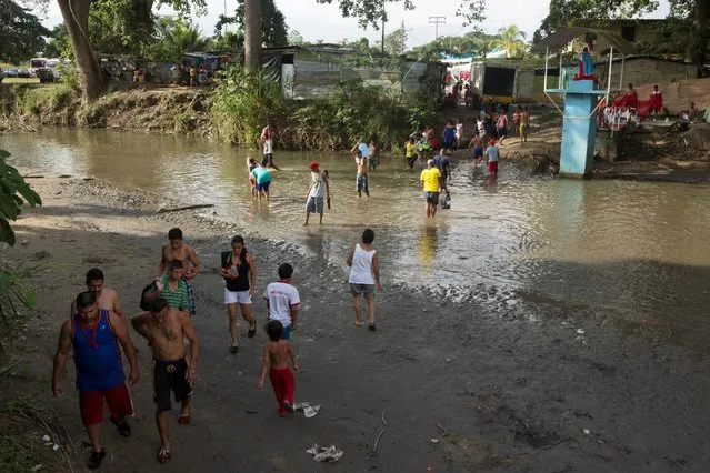 People cross a river at a hamlet in the Sorte Mountain on the outskirts of Chivacoa, in the state of Yaracuy, Venezuela October 11, 2015. (Photo by Marco Bello/Reuters)