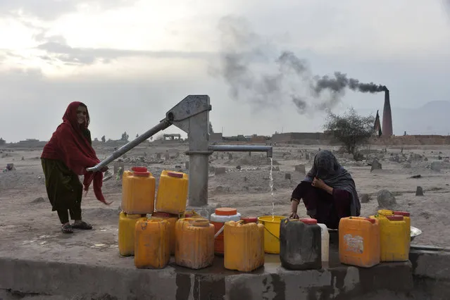 In this photograph taken on February 3, 2020, women collect water from a hand water pump on the outskirts of Jalalabad. (Photo by Noorullah Shirzada/AFP Photo)