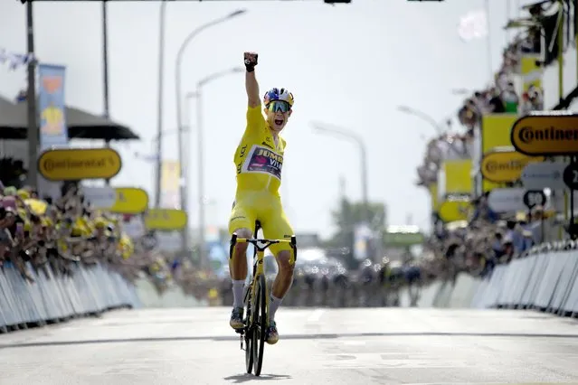 Belgium's Wout Van Aert, wearing the overall leader's yellow jersey celebrates as he crosses the finish line to win the fourth stage of the Tour de France cycling race over 171.5 kilometers (106.6 miles) with start in Dunkerque and finish in Calais, France, Tuesday, July 5, 2022. (Photo by Daniel Cole/AP Photo)