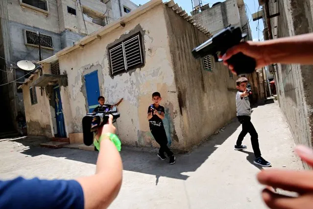 Palestinian children play with toy guns in the southern Gaza Strip town of Rafah on July 7, 2016, on the second day of Eid al-Fitr holiday, which marks the end of the holy Muslim month of Ramadan. (Photo by Said Khatib/AFP Photo)