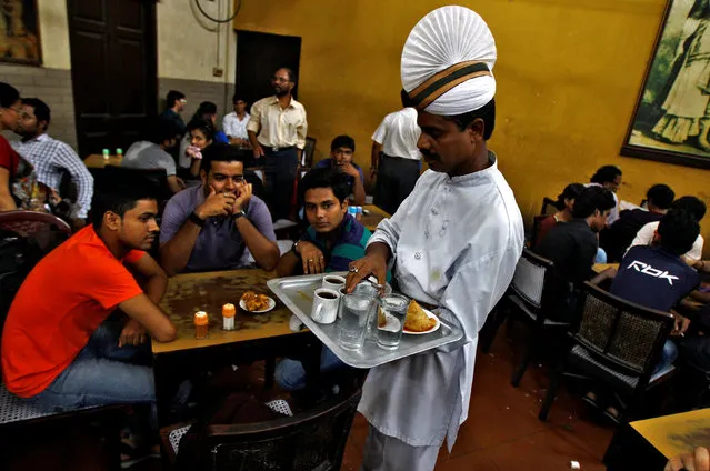 A waiter serves coffee to customers inside an Indian coffee house in Kolkata June 20, 2014. (Photo by Rupak De Chowdhuri/Reuters)