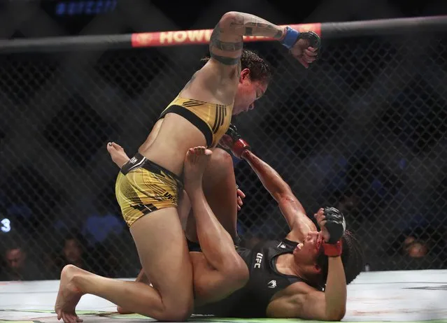 Amanda Nunes, top, goes to strike Julianna Pena during a mixed martial arts women's bantamweight title bout at UFC 277 on Saturday, July 30, 2022, in Dallas. (Photo by Richard W. Rodriguez/AP Photo)