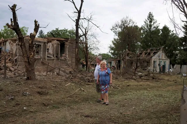 Neighbours look on next to destroyed houses in Kramatorsk, after military strikes as Russia's invasion of Ukraine continues, in Donetsk region, Ukraine on August 16, 2022. (Photo by Nacho Doce/Reuters)