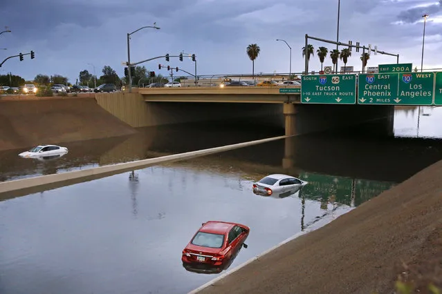 Cars sit stranded in flood waters along Interstate 17, Tuesday, August 2, 2016 in Phoenix. wo high schools in southern Arizona were evacuated as a precaution Tuesday and some drivers had to be rescued as flooding closed several major roads and stranded motorists between flowing washes. (Photo by David Kadlubowski/The Arizona Republic via AP Photo)