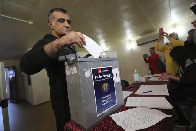 A man from Luhansk region, the territory controlled by a pro-Russia separatist government, but who lives in Russia, votes at temporary accommodation facility in Volgograd, Russia, Friday, September 23, 2022. Voting began Friday in four Moscow-held regions of Ukraine on referendums to become part of Russia. Polls also opened in Russia, where refugees from regions under Russian control can cast their votes. (Photo by AP Photo/Stringer)