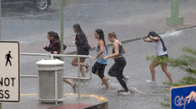 Several young women get drenched as they race through the rain at the University of Arizona Tuesday, August 9, 2016, in Tucson, Ariz. Heavy rain associated with Tropical Storm Javier in Mexico fell over the American Southwest. (Photo by A.E. Araiza/Arizona Daily Star via AP Photo)