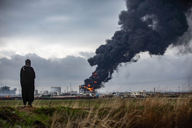 Thick smoke billows from a raging fire at a storage tank of the al-Awda oil field facility near al-Qahtaniyah in northeastern Syria close to the Turkish border on December 24, 2023, a day after a reported Turkish strike. An AFP correspondent as well as the Syrian Observatory for Human Rights reported strikes on December 23 evening against two oil sites in northeast Syria, near the Turkish border, without reporting any victims. (Photo by Delil Souleiman/AFP Photo)