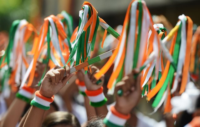 Indian schoolchildren with tri-colour bands on their wrists participate in a drill for Independence Day celebrations at a school in Kolkata on August 15, 2016. Prime Minister Narendra Modi said India was becoming the world's most attractive destination for foreign investors, using his annual Independence Day speech to trumpet sweeping tax reforms designed to spur growth. In an address from Delhi's 17th-century Red Fort, Modi sought to highlight his government's achievements, including the recent passage of a landmark tax reform, that have contributed to India's robust growth during a global slowdown. (Photo by Dibyangshu Sarkar/AFP Photo)