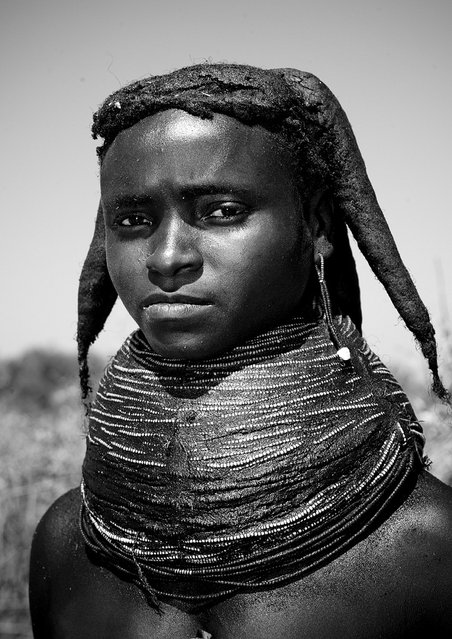 “Mwila tribe girl – Angola. Mwila (or Mwela, Mumuhuila, or Muhuila) women are famous for their very special hairstyles. Hairstyles are very important and meaningful in Mwila culture. Women coat their hair with a red paste called, oncula, which is made of crushed red stone. They also put a mix of oil, crushed tree bark, dried cow dung and herbs on their hair”. (Eric Lafforgue)