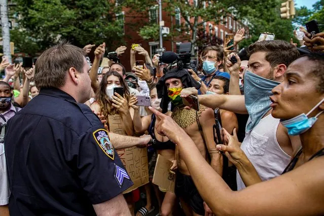 Demonstrators react in the presence of a New York Police Department (NYPD) police officer at a joint LGBTQ and Black Lives Matter march on the 51st anniversary of the Stonewall riots in New York City, New York, June 28, 2020. (Photo by Eduardo Munoz/Reuters)