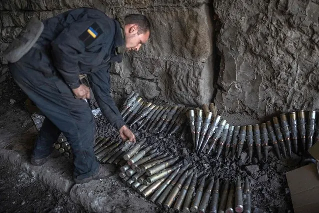 A Ukrainian soldier sorts ammunition in Bakhmut, eastern Ukraine, on November 9, 2022, amid the Russian invasion of Ukraine. (Photo by Bulent Kilic/AFP Photo)
