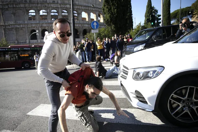 Police remove protesters of Last Generation who were blocking traffic in front of Colosseum in downtown Rome, to protest against the environment crisis Friday, November 11, 2022. (Photo by Cecilia Fabiano/LaPresse via AP Photo)