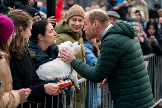 Britain's Prince William pets a woman's dog as people gather to watch, during his visit to Tallinn, Estonia, Thursday, March 20, 2025. (Photo by Sergei Grits/AP Photo)