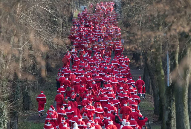 Participants dressed in Father Christmas costumes take part in the traditional Santa Claus run in Michendorf, eastern Germany, on December 10, 2017. (Photo by Ralf Hirschberger/AFP Photo/DPA)