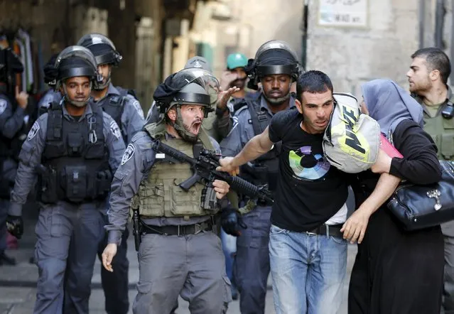 An Israeli policeman prevents a Palestinian man from entering the compound which houses al-Aqsa mosque, known by Muslims as the Noble Sanctuary and by Jews as the Temple Mount, in Jerusalem's Old City September 28, 2015. (Photo by Ammar Awad/Reuters)