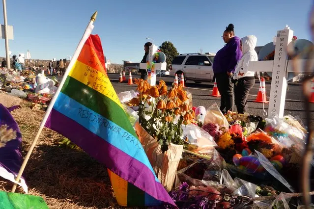 People visit a makeshift memorial near the Club Q nightclub on November 22, 2022 in Colorado Springs, Colorado. On November 19, a 22-year-old gunman entered the LGBTQ nightclub and opened fire, killing five people before being tackled and disarmed by a club patron. (Photo by Scott Olson/Getty Images)