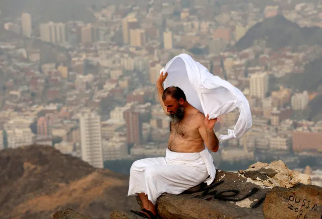 A Muslim pilgrim sits on the top of Mount Al-Noor, where Muslims believe Prophet Mohammad received the first words of the Koran through Gabriel in the Hera cave, ahead of the annual haj pilgrimage in the holy city of Mecca, Saudi Arabia September 7, 2016. (Photo by Ahmed Jadallah/Reuters)