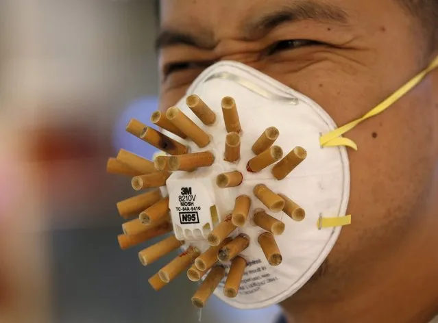 A man wears a mask decorated with cigarette butts, designed by Chinese designer Wen Fang at Wen's "Maskbook" workshop during the Beijing Design Week 2015 in Beijing, China, October 2, 2015. In the workshop, participants decorated and designed masks with their own ideas, as a symbol of collective citizen action for climate change, and against pollution and smoking in public place, the designer said. (Photo by Kim Kyung-Hoon/Reuters)
