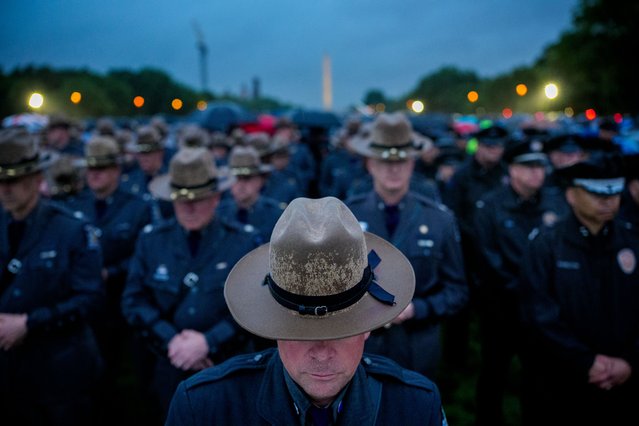 Police officers stand in the rain along with thousands of law enforcement officers and their family and supporters for the National Police Week 37th annual candlelight vigil on the National Mall on May 13, 2025 in Washington, DC. Police, political leaders and family members of those officers who died in the line of duty gathered on the National Mall to remember and honor them. (Photo by Andrew Harnik/Getty Images)