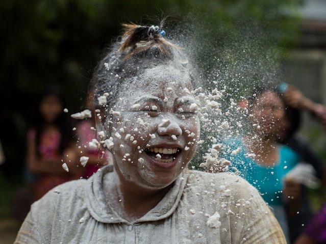 A woman reacts with flour over her face while playing a game with cake-making ingredients as part of local festivities marking Myanmar's 70th Independence Day in Yangon on January 4, 2018. The country is celebrating the 70th anniversary of its declaration of independence from British colonial rule. (Photo by Ye Aung Thu/AFP Photo)