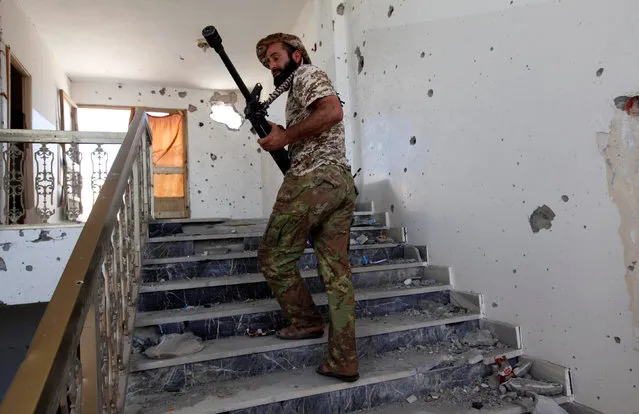 A fighter from Libyan forces allied with the U.N.-backed government walks up the stairs of a building during a battle with Islamic State militants in Sirte, Libya September 24, 2016. (Photo by Ismail Zitouny/Reuters)