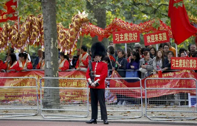 A guardsman stands on duty in front of supporters of China's President Xi Jinping as they wait on the Mall for him to pass during his ceremonial welcome, in London, Britain, October 20, 2015. (Photo by Peter Nicholls/Reuters)