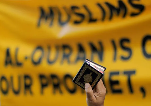 A man holds a copy of the Koran during a protest in front of the Swedish embassy after Rasmus Paludan, leader of Danish far-right political party Hard Line burned a copy of the Koran near the Turkish Embassy in Stockholm, in Kuala Lumpur, Malaysia on January 27, 2023. (Photo by Hasnoor Hussain/Reuters)