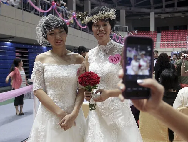 A same-s*x couple poses for a picture during a mass wedding ceremony in Taipei, Taiwan, October 24, 2015. 123 couples tied the knot together on Saturday, including six same-s*x couples, with Taipei mayor Ko Wen-je as the witness for the ceremony, according to the organiser. (Photo by Pichi Chuang/Reuters)