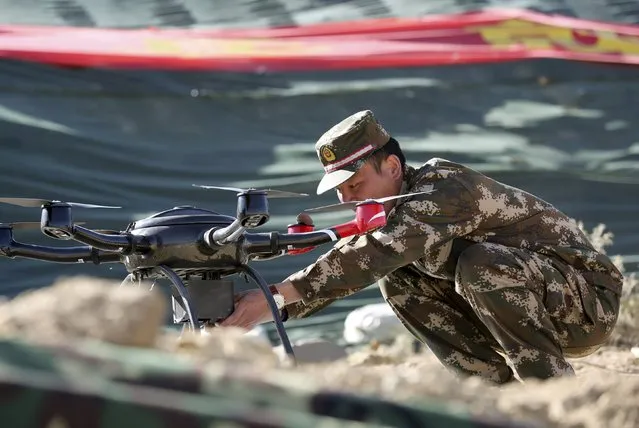 A police officer prepares a drone for display during a drill at a military base in Shigatse, Tibet Autonomous Region, China, October 25, 2015. (Photo by Reuters/Stringer)