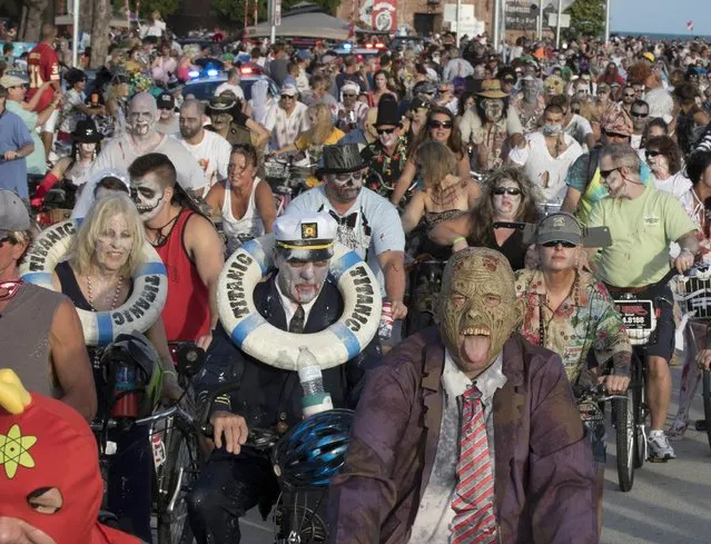 Costumed participants in the Zombie Bike Ride pedal down South Roosevelt Boulevard in Key West, Florida, October 25, 2015. (Photo by Rob O'Neal/Reuters/Florida Keys News Bureau)