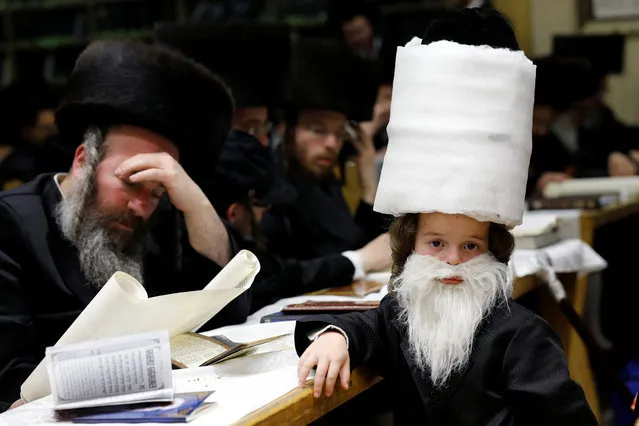 Ultra-Orthodox Jews take part in the reading from the Book of Esther, a ceremony performed on the Jewish holiday of Purim, in a synagogue in Ashdod, Israel on February 28, 2018. (Photo by Amir Cohen/Reuters)