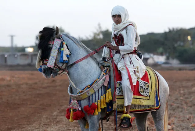 A boy wearing a traditional costume rides a horse as he parades during a wedding celebration in Shahhat, Libya October 1, 2016. (Photo by Esam Omran Al-Fetori/Reuters)