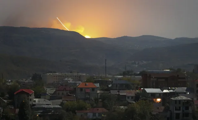 Explosions are seen behind the mountains during a military conflict outside Stepanakert, the separatist region of Nagorno-Karabakh, Friday, October 30, 2020. The Azerbaijani army has closed in on a key town in the separatist territory of Nagorno-Karabakh following more than a month of intense fighting. (Photo by AP Photo/Stringer)