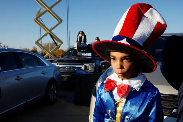 A boy dressed in the colors of the U.S. flag waits for the start of a campaign drive-in, get-out-the-vote event with Democratic U.S. presidential nominee Joe Biden and former U.S. President Barack Obama in Detroit, Michigan, U.S., October 31, 2020. (Photo by Brian Snyder/Reuters)