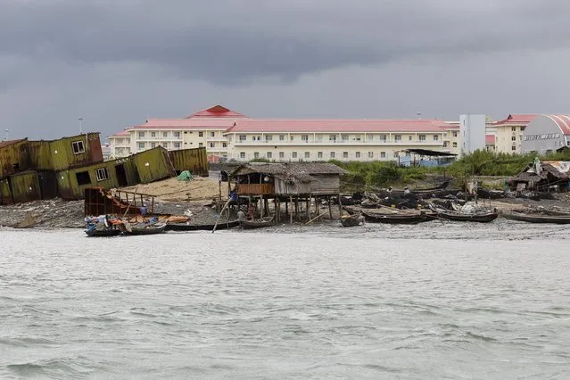 Local residents' houses are seen in front of the buildings of the Chinese oil pipeline project (pink roof) on Madae island, Kyaukpyu township, Rakhine state, Myanmar October 7, 2015. (Photo by Soe Zeya Tun/Reuters)