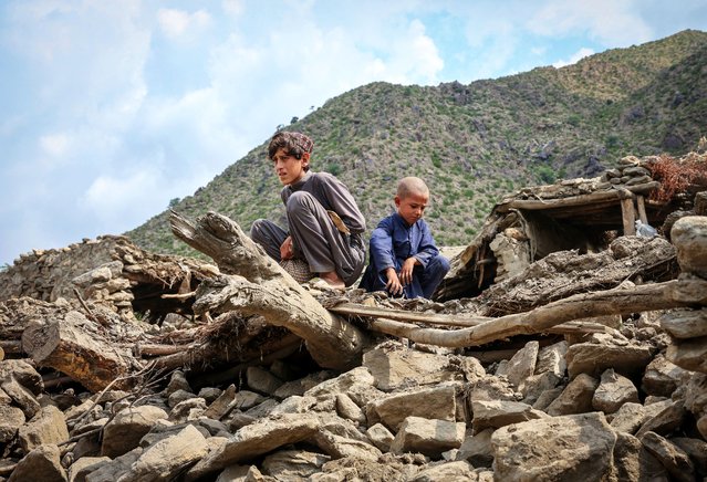 Afghan boys sit on the rubble of a house following a deadly magnitude-6 earthquake that struck Afghanistan on Sunday, at Lulam village, in Nurgal district, Kunar province, Afghanistan, on September 3, 2025. (Photo by Sayed Hassib/Reuters)